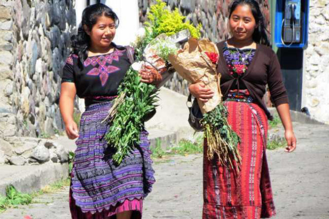 Indigenas mit Blumensträußen